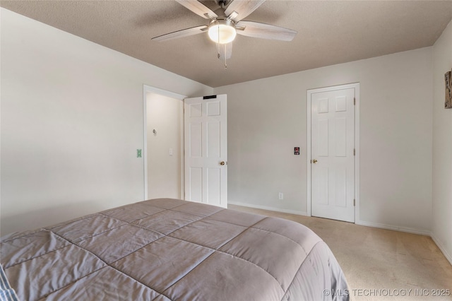 bedroom featuring a ceiling fan, a textured ceiling, baseboards, and carpet flooring