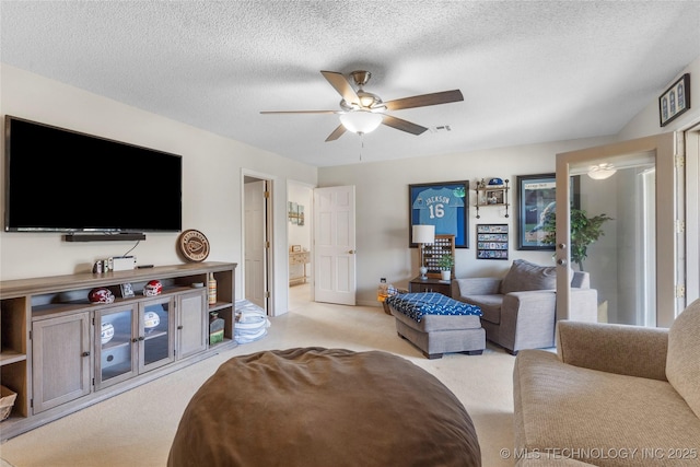 living area featuring a textured ceiling, a ceiling fan, and carpet flooring