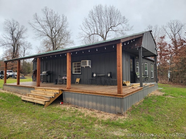 back of house with board and batten siding, a yard, a wooden deck, and a wall mounted AC