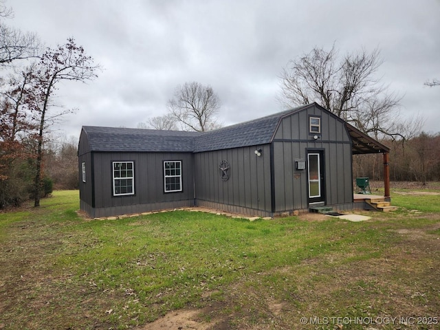 exterior space featuring roof with shingles, a lawn, and a gambrel roof