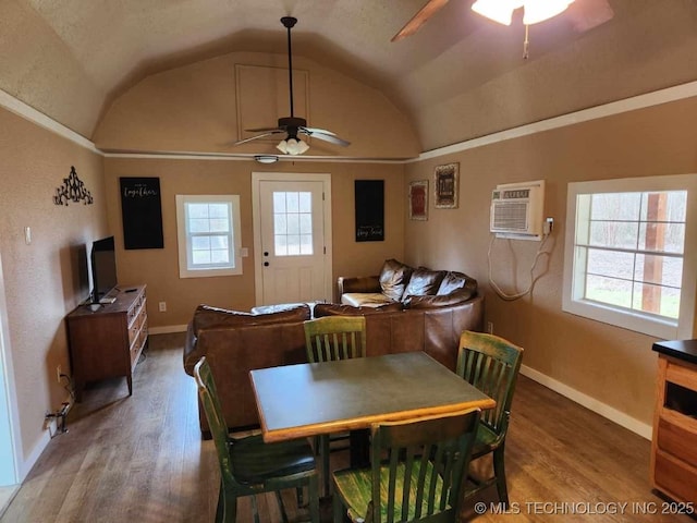 dining room with lofted ceiling, a ceiling fan, wood finished floors, and a wall mounted AC