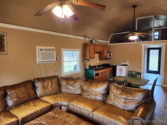 living area with a ceiling fan, an AC wall unit, vaulted ceiling, and wood finished floors