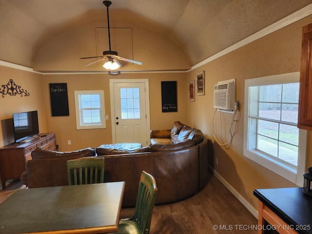 living area featuring lofted ceiling, wood finished floors, a ceiling fan, baseboards, and an AC wall unit