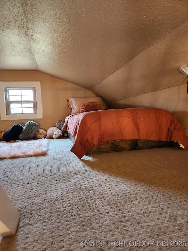 carpeted bedroom with a textured ceiling and vaulted ceiling