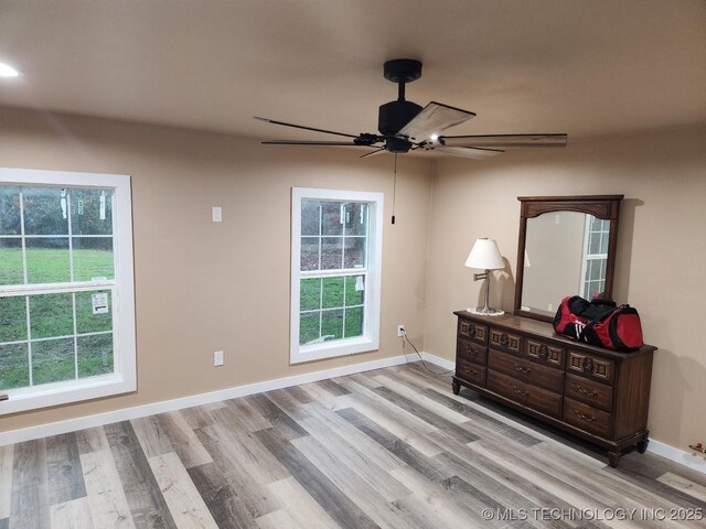 bedroom featuring a ceiling fan, baseboards, and wood finished floors