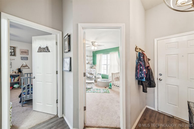 foyer featuring ceiling fan, baseboards, and dark wood finished floors