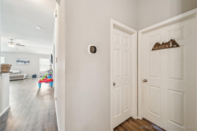 hall featuring dark wood-style floors and baseboards