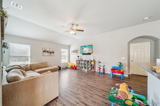 living room featuring visible vents, arched walkways, a ceiling fan, lofted ceiling, and wood finished floors