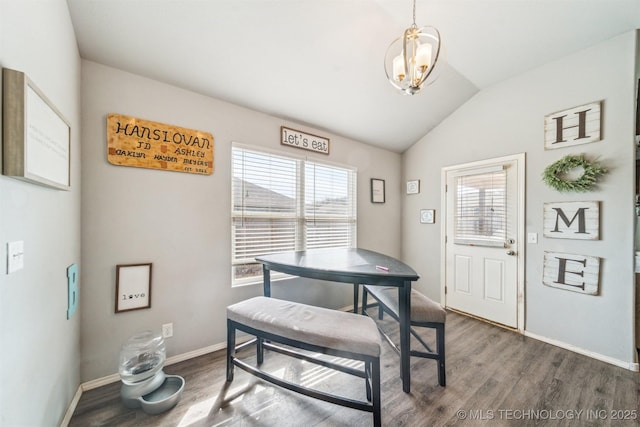 dining area with lofted ceiling, baseboards, wood finished floors, and a notable chandelier