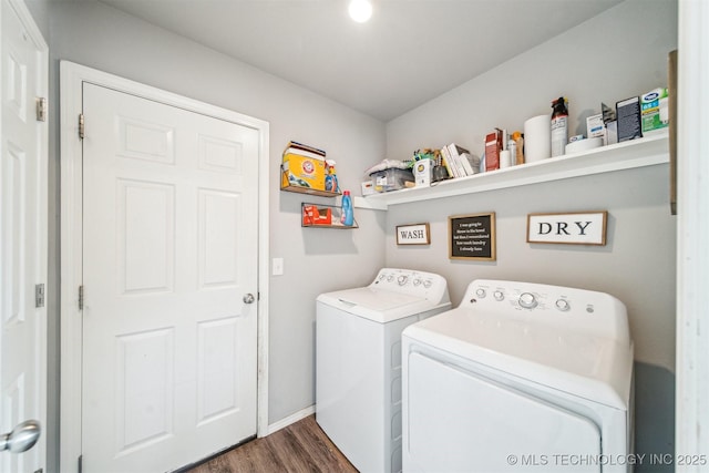 laundry area with laundry area, baseboards, dark wood finished floors, and washing machine and clothes dryer