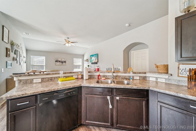 kitchen featuring black dishwasher, a sink, ceiling fan, dark brown cabinets, and a peninsula