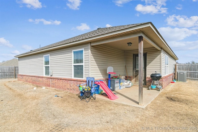 rear view of property featuring a patio area, fence, and brick siding