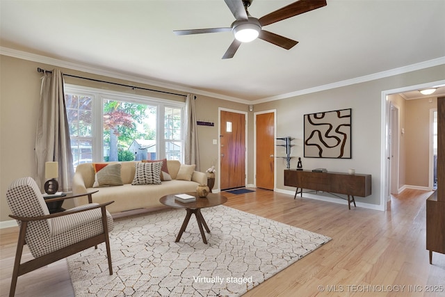 living room with light wood-style floors, baseboards, and crown molding