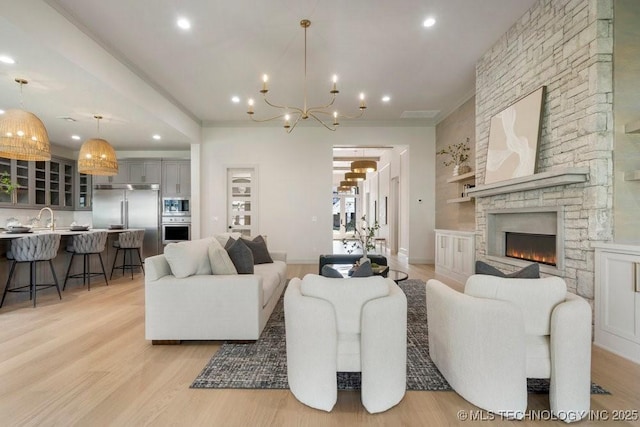12030 S Vandalia Ave, Tulsa, OK 74137 - living area featuring a chandelier, light wood finished floors, recessed lighting, ornamental molding, and a fireplace