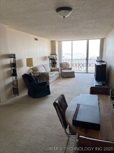 carpeted living room featuring expansive windows, visible vents, and a textured ceiling