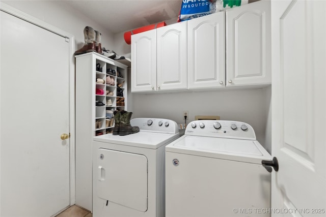 laundry room featuring washing machine and clothes dryer and cabinet space