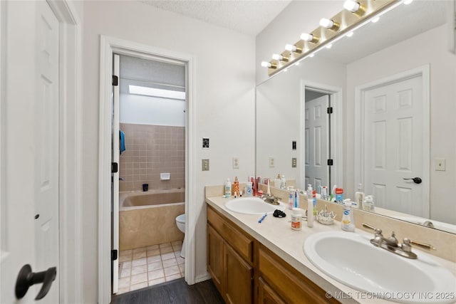 bathroom with double vanity, a sink, a textured ceiling, and a bath