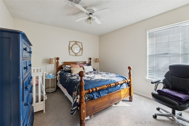 carpeted bedroom featuring a textured ceiling, visible vents, a ceiling fan, and baseboards