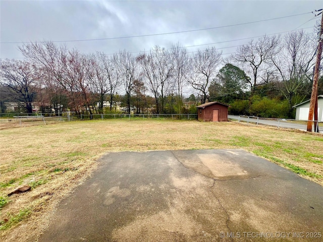 view of yard with a storage shed, fence, and an outdoor structure