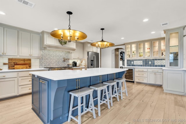 kitchen featuring visible vents, high end refrigerator, arched walkways, and beverage cooler