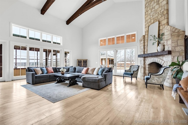 living area with french doors, a fireplace, wood-type flooring, and beamed ceiling