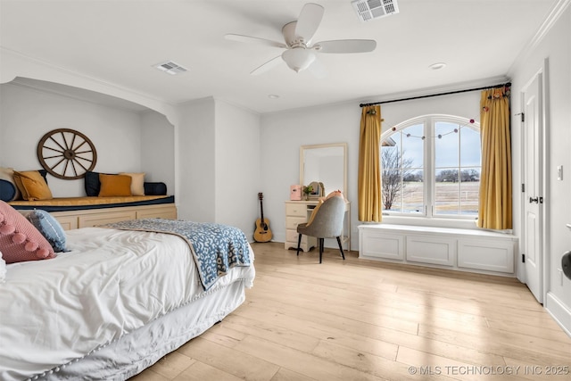 bedroom with light wood-style flooring, visible vents, ceiling fan, and ornamental molding