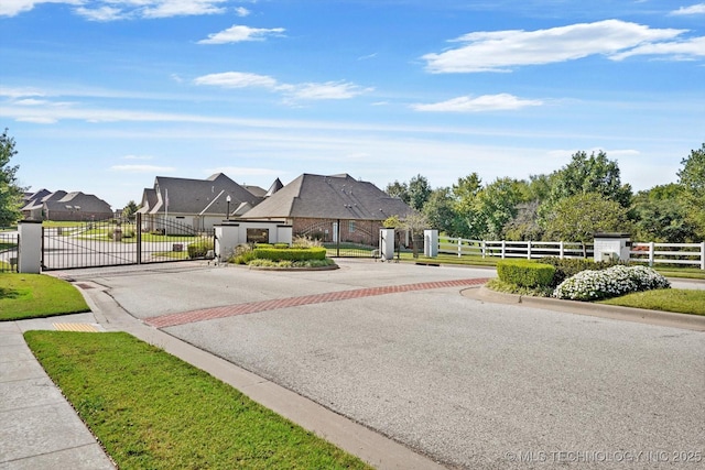 view of road with a gate, curbs, and a gated entry