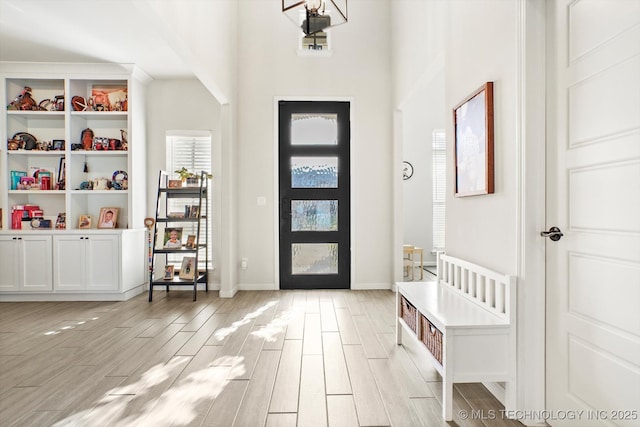 entrance foyer with arched walkways, wood finish floors, and baseboards