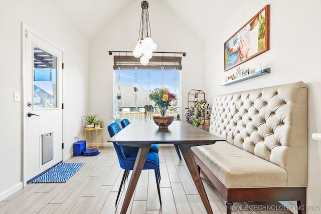 dining area featuring lofted ceiling, wood finish floors, and baseboards