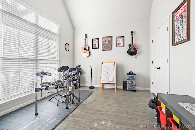 home office featuring vaulted ceiling, baseboards, and wood finished floors