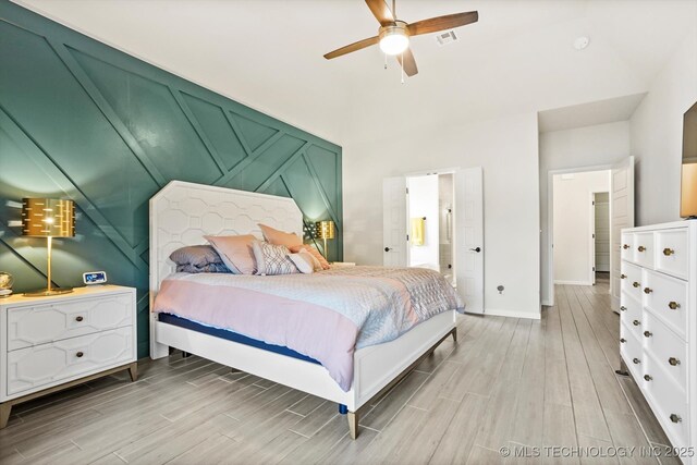 bedroom featuring baseboards, visible vents, a ceiling fan, and wood tiled floor