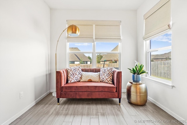 living area with light wood-type flooring and baseboards