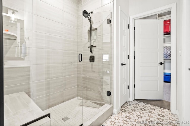 bathroom with a shower stall and tile patterned floors