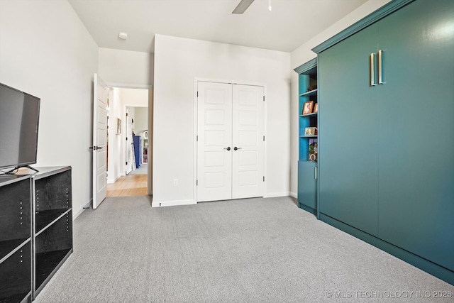 bedroom with a closet, carpet, a ceiling fan, and baseboards