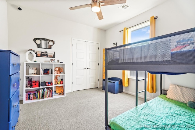 carpeted bedroom with a ceiling fan, a closet, visible vents, and baseboards