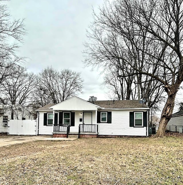 view of front of property featuring covered porch, a front lawn, fence, and a gate