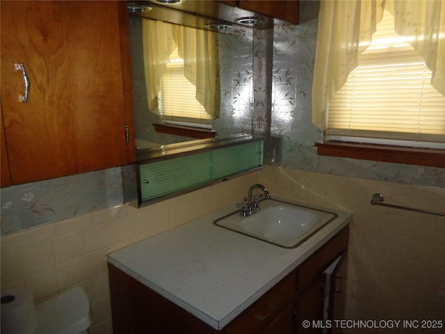 bathroom with vanity and tile walls