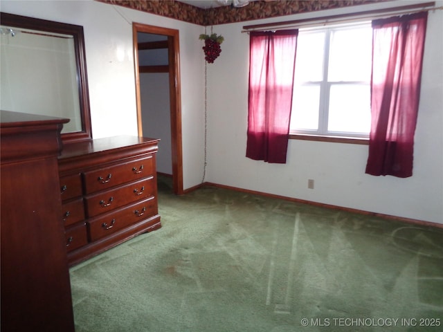 unfurnished bedroom featuring carpet and baseboards