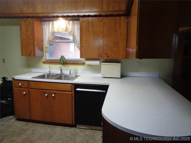 kitchen with black dishwasher, light countertops, brown cabinetry, and a sink