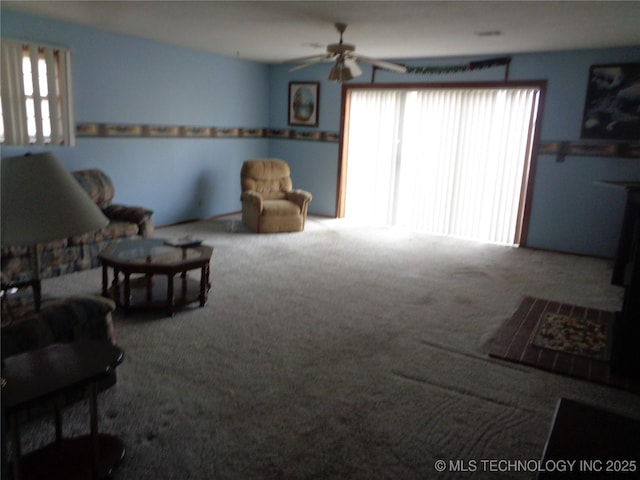 living area with a ceiling fan and carpet flooring