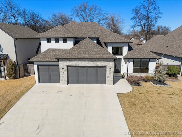 view of front of home featuring an attached garage, a shingled roof, a front yard, and concrete driveway