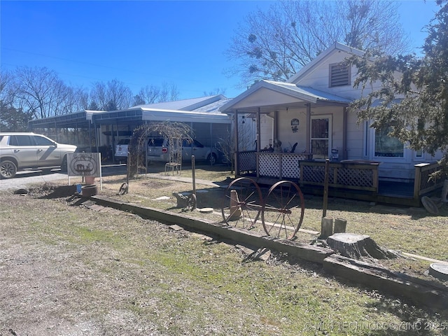 view of front of house featuring driveway, metal roof, and a carport