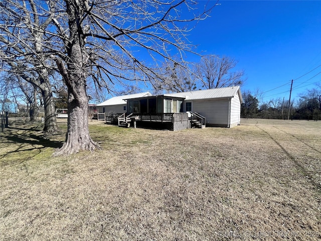 rear view of house featuring metal roof and a lawn