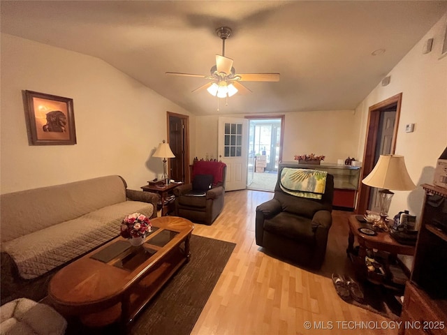 living room featuring a ceiling fan, lofted ceiling, and light wood finished floors