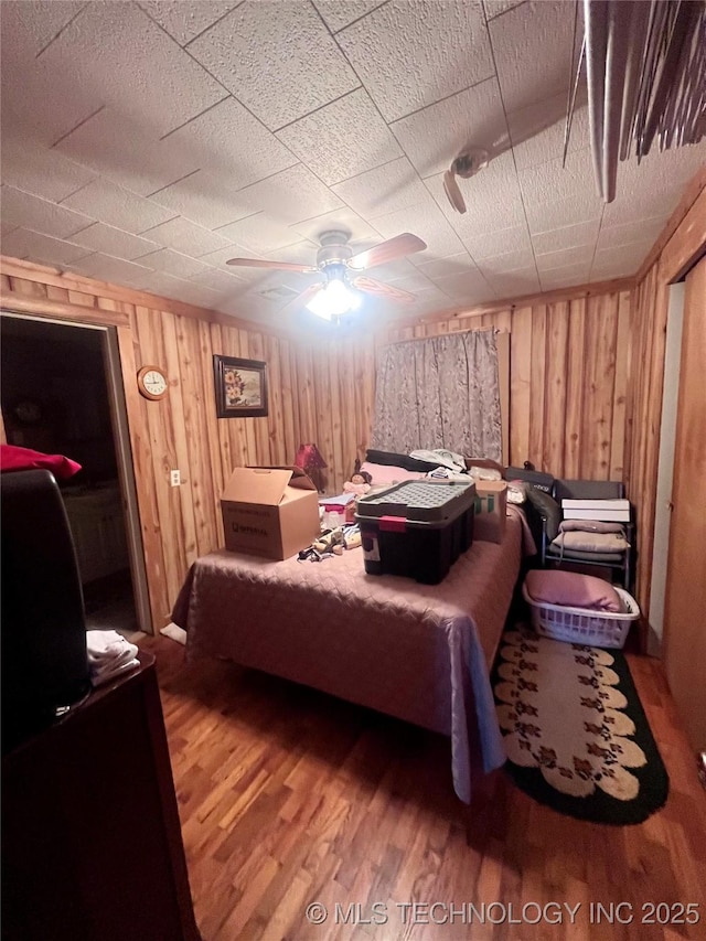 bedroom with wooden walls and wood finished floors