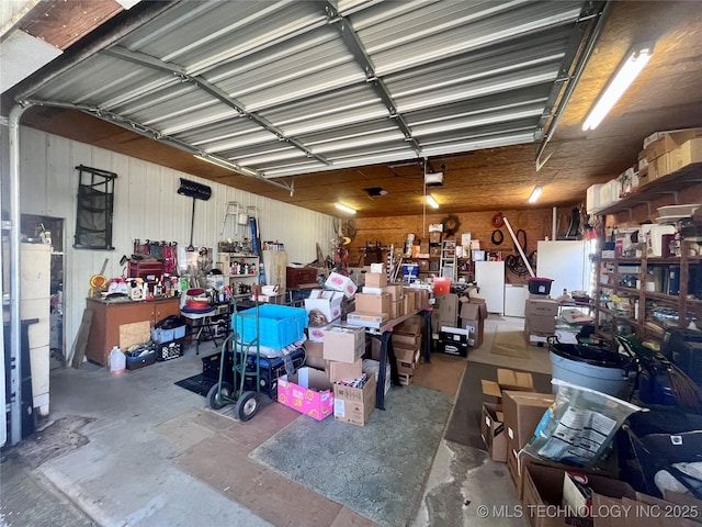 garage featuring freestanding refrigerator and metal wall