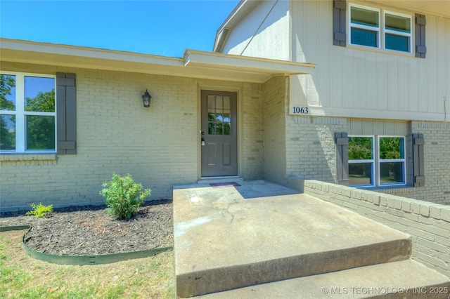 doorway to property with brick siding