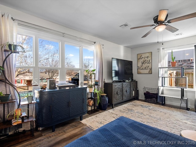 living room with visible vents, ceiling fan, and wood finished floors