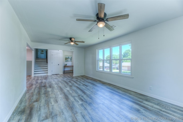 unfurnished bedroom featuring a ceiling fan, visible vents, baseboards, and wood finished floors