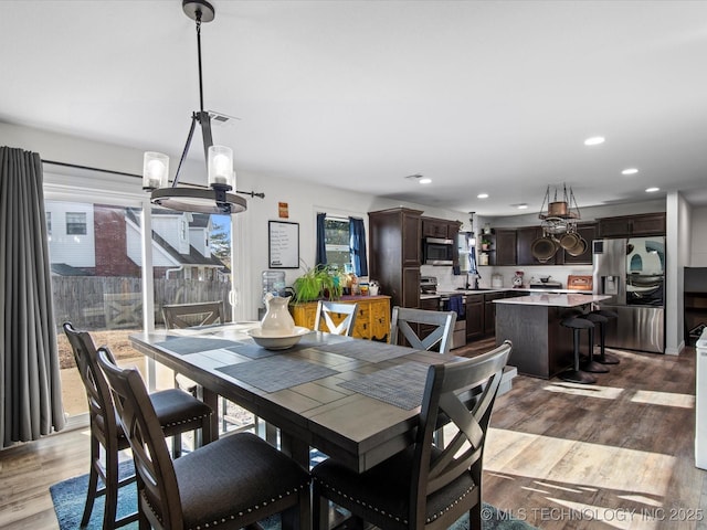 dining space featuring an inviting chandelier, wood finished floors, and recessed lighting